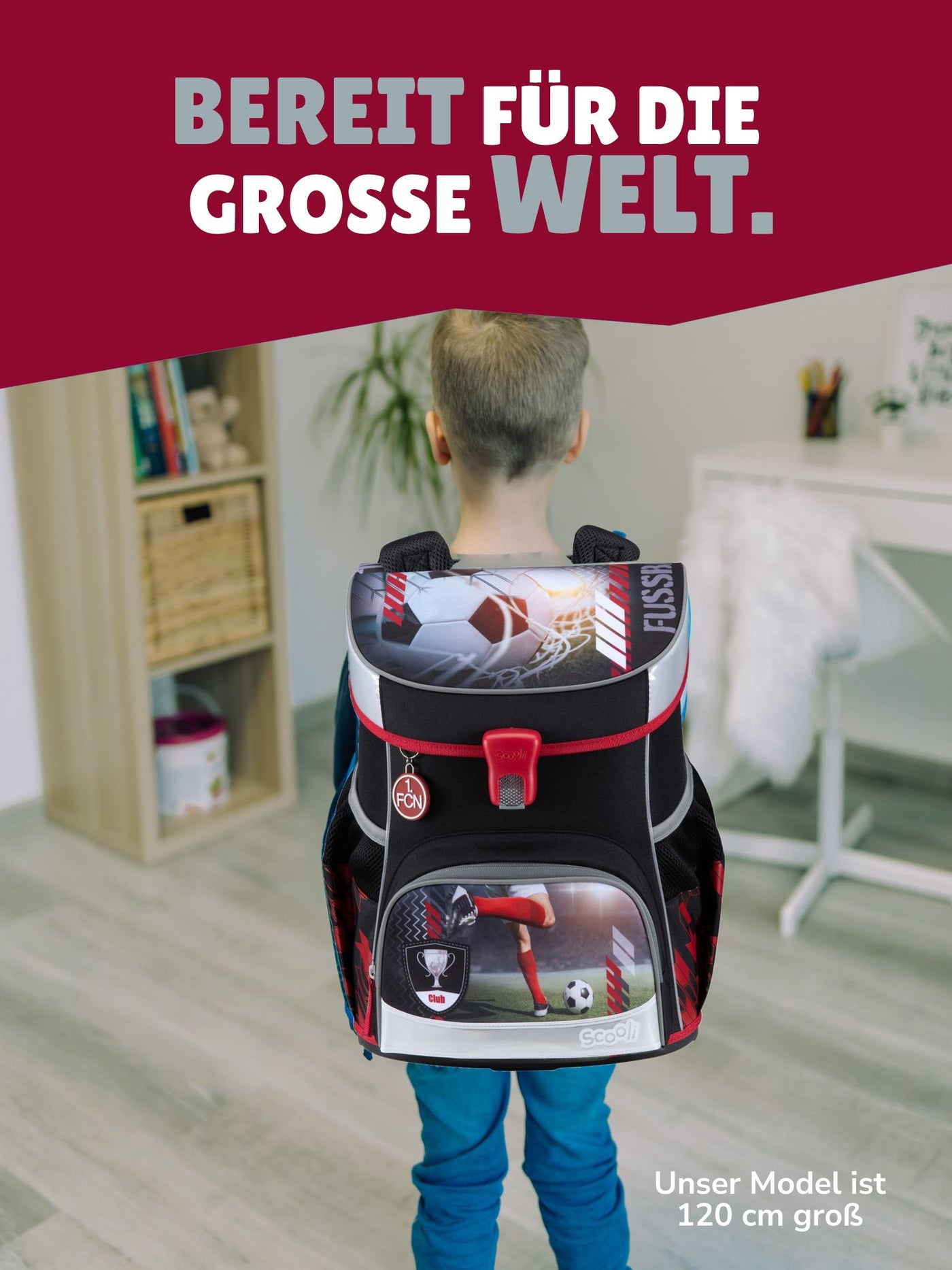 Junge steht mit Schulranzen auf dem Rücken zur Kamera - Spruchbanner "Bereit für die grosse Welt"