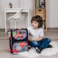 Junge sitzt am Boden mit dem Avengers Schulranzen in schwarz grau