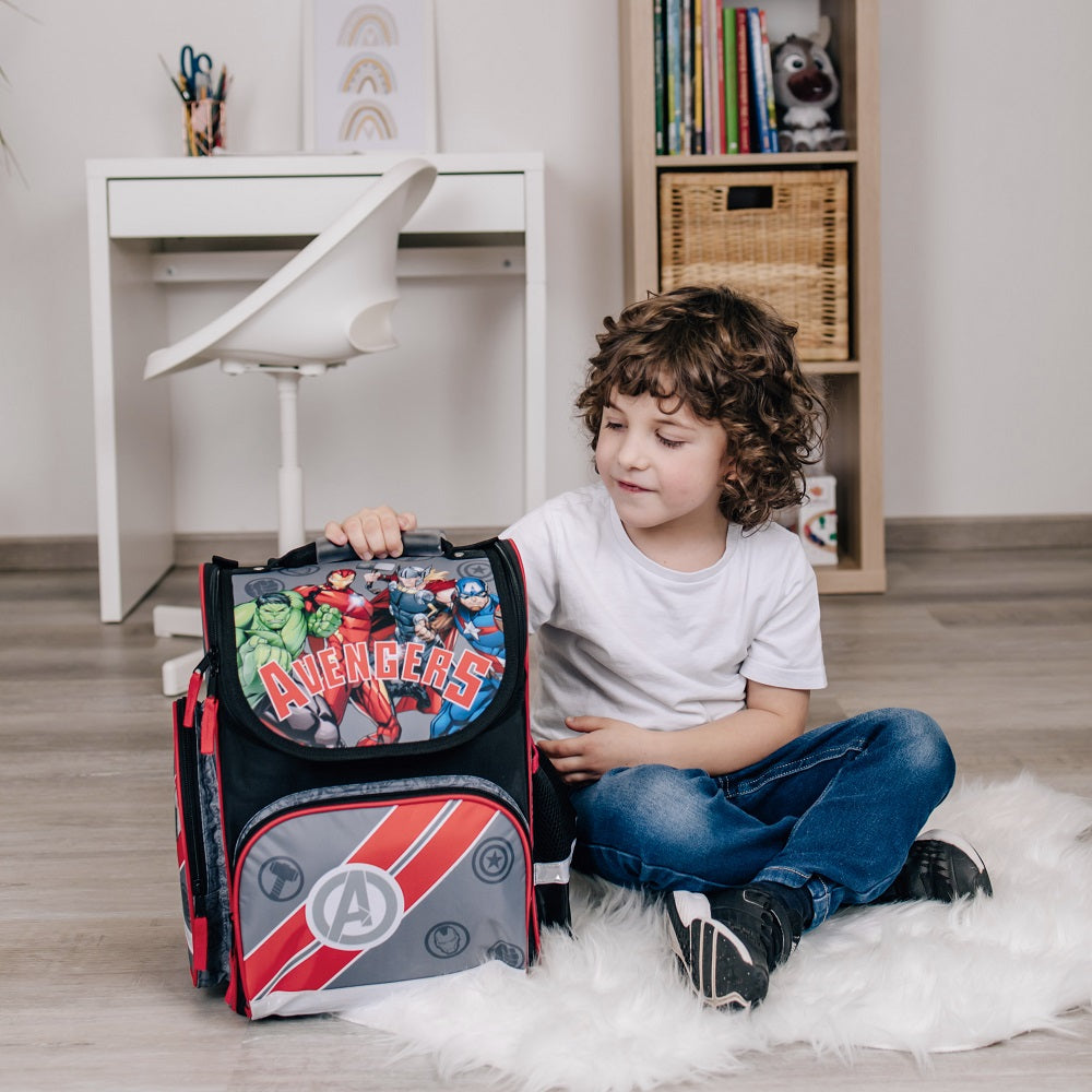 Junge sitzt am Boden mit dem Avengers Schulranzen in schwarz grau
