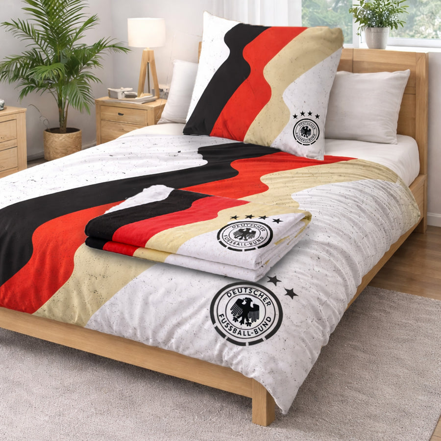 DFB Bettwäsche weiß mit Deutschlandfarben und DFB LOGO auf Bett gezogen - darauf liegt ein passendes gefaltetes Handtuch