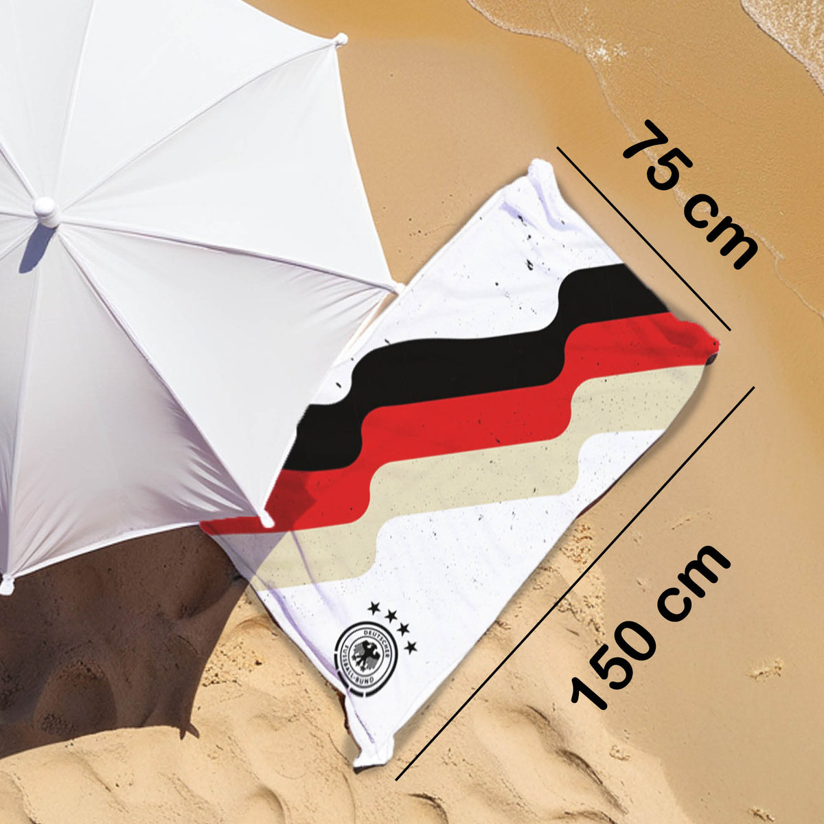 DFB Strandtuch liegt am Strand neben Schirm mit Maßangaben 75 x 150 cm
