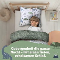 Junge schläft seelig lächeln in Dino Bettwäsche