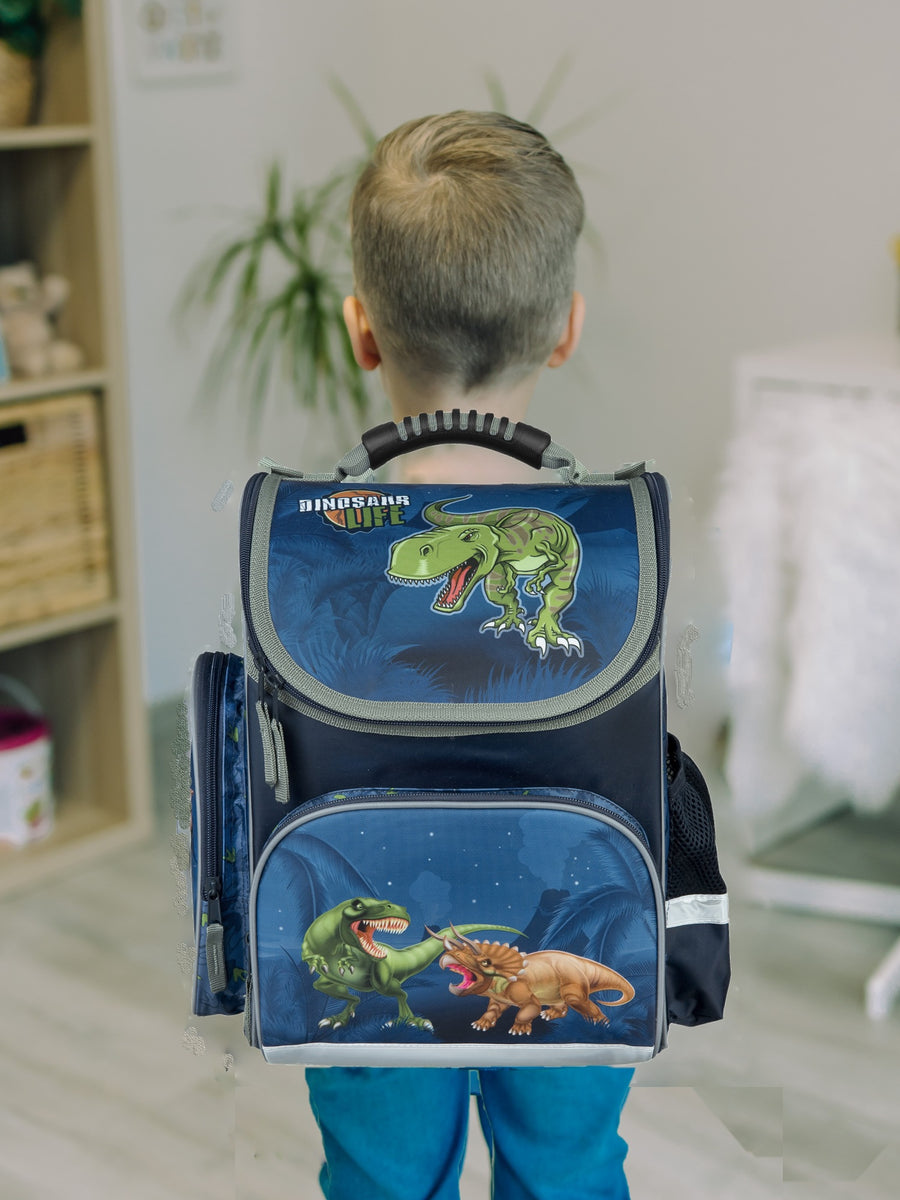 Junge trägt Dino Schulranzen auf dem Rücken