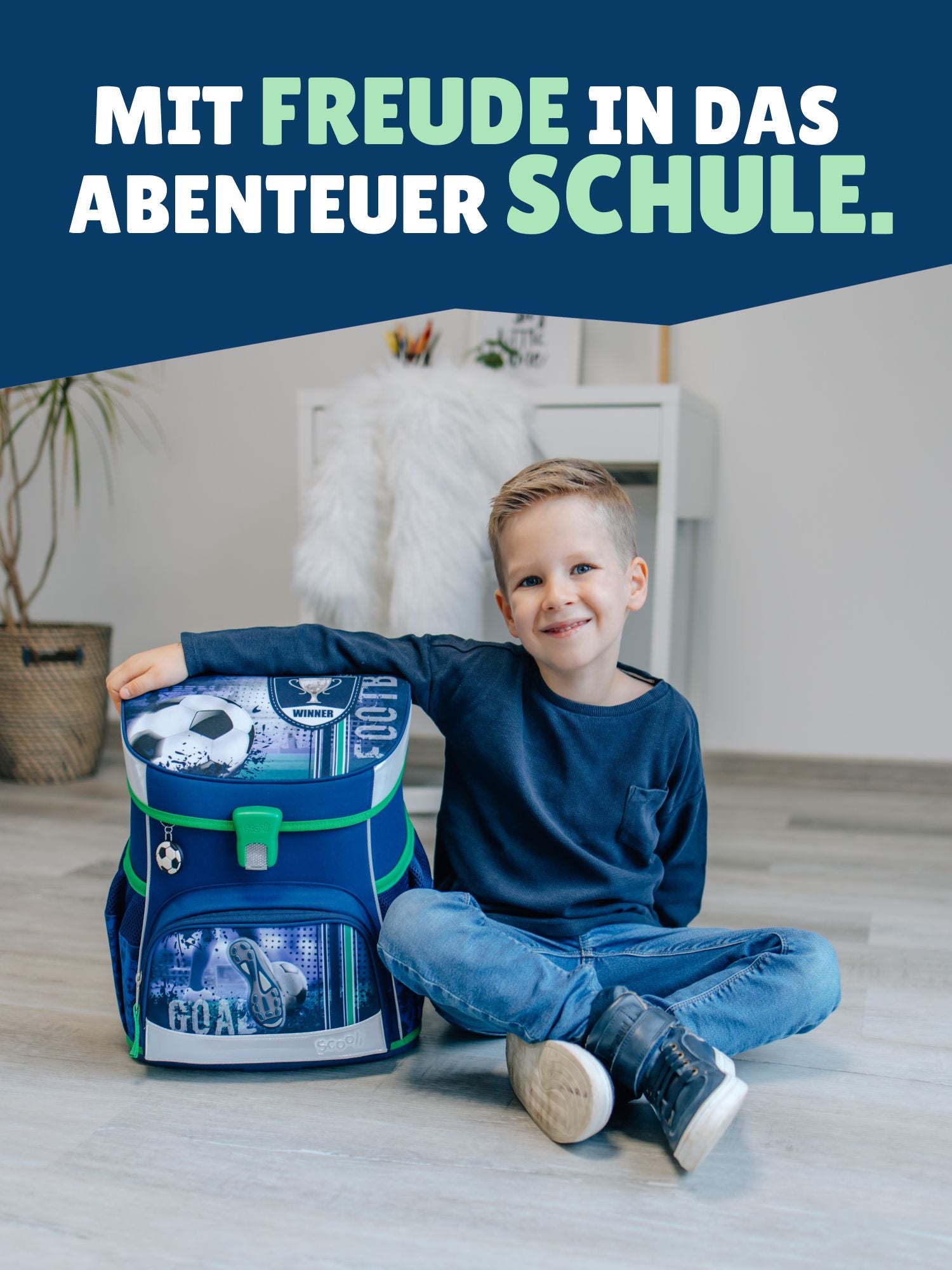 Jungen sitzt neben Schulranzen mit Spruch-Banner "Mit Freude in das Abenteuer Schule"
