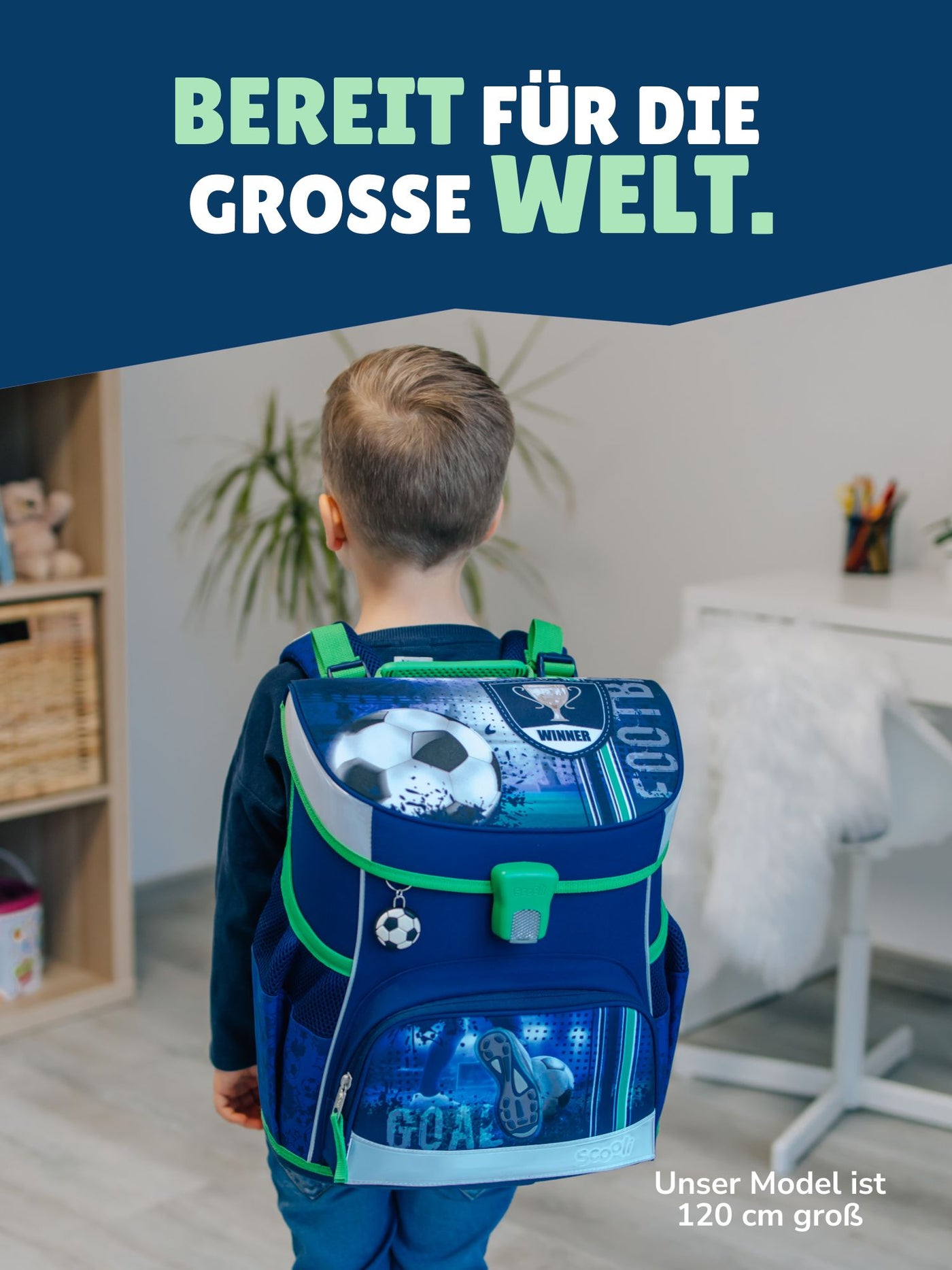 Jungen steht in hellem Wohnzimmer mit Fußball Schulranzen auf dem Rücken - Spruch "Bereit für die grosse Welt"