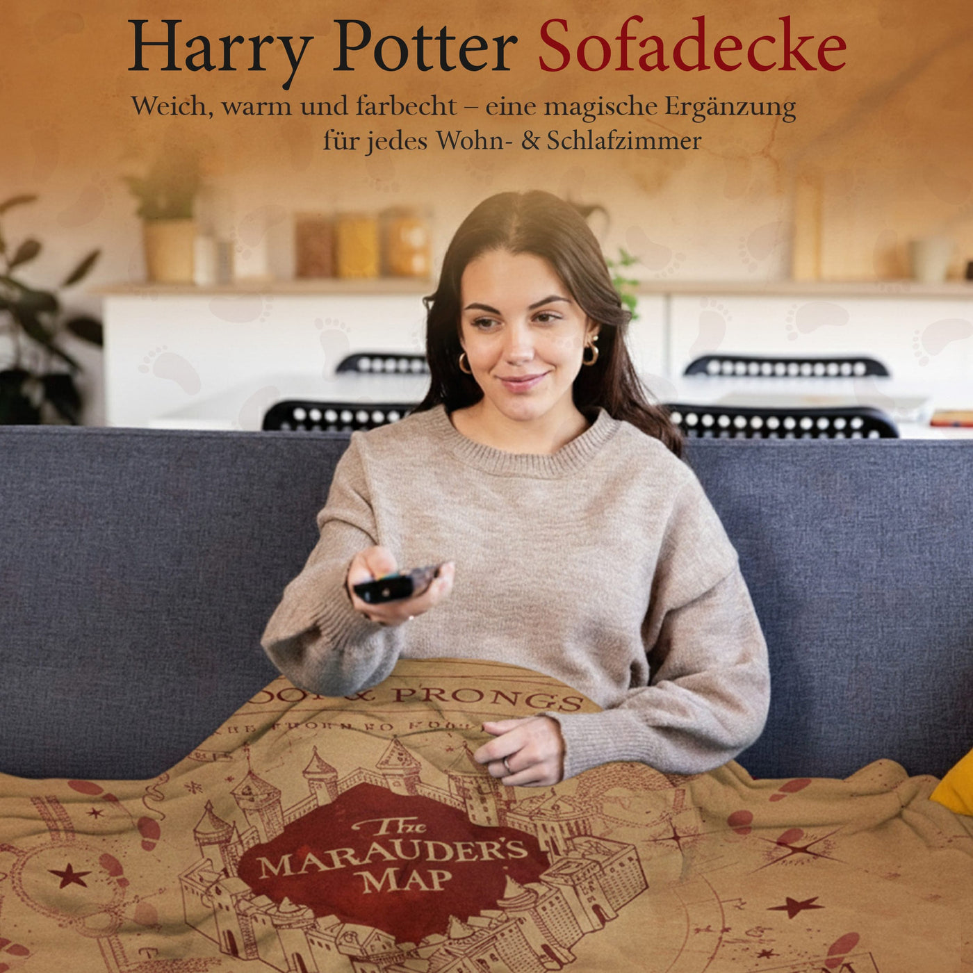 Frau sitzt auf der Couch uns sieht fern während sie sich in die Harry Potter Rumtreiber Decke kuschelt