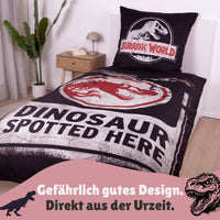 Vorderseite der Jurassic World Bettwäsche auf Bett gezogen mit T-Rex Logo und Spruch "Dinosaur spottet here"