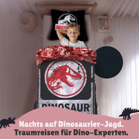 Junge schläft seelig lächelnd in der Bettwäsche