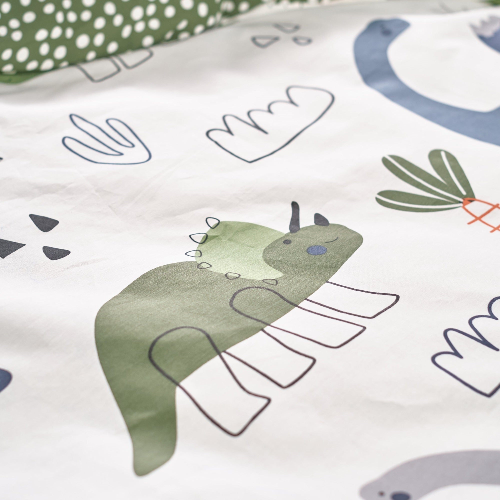 Detailansicht grüner Triceratops Dino auf Bettdecke