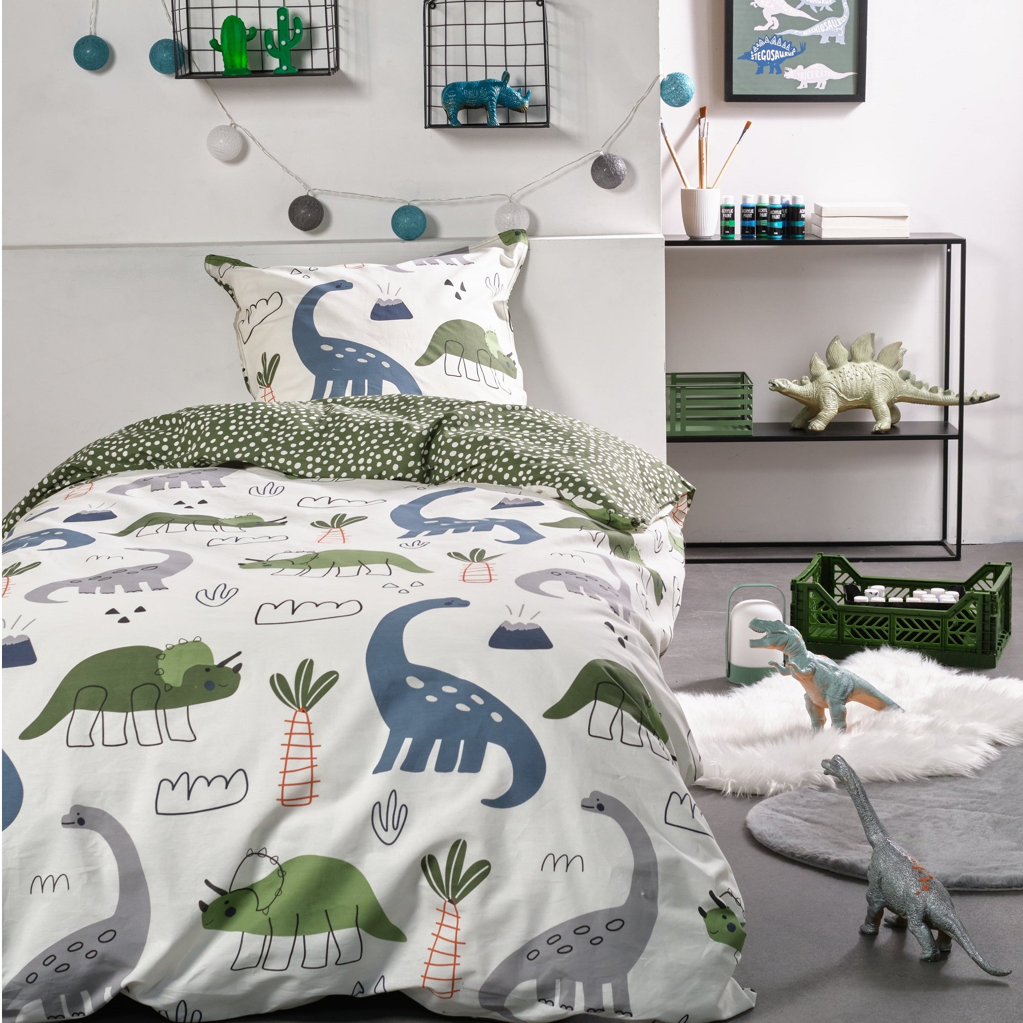 Kinderbettwäsche mit Dinosauriern in weißem Design im passend dekorierten Kinderzimmer auf Bett