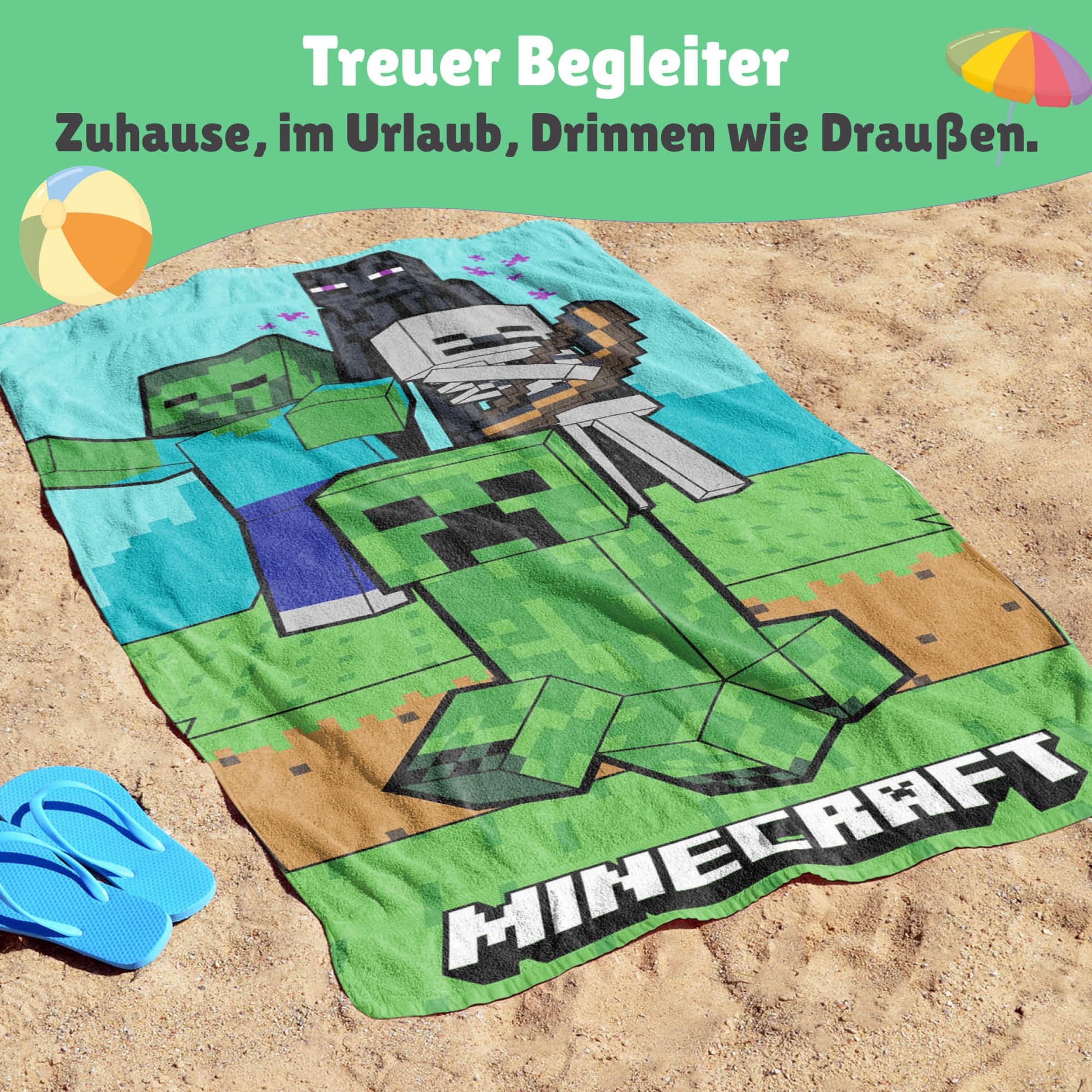 Nahaufnahme Minecraft Strandtuch das am Strand liegt mit Schriftzug unten und oben die Figuren Creeper, Zombie und Enderman