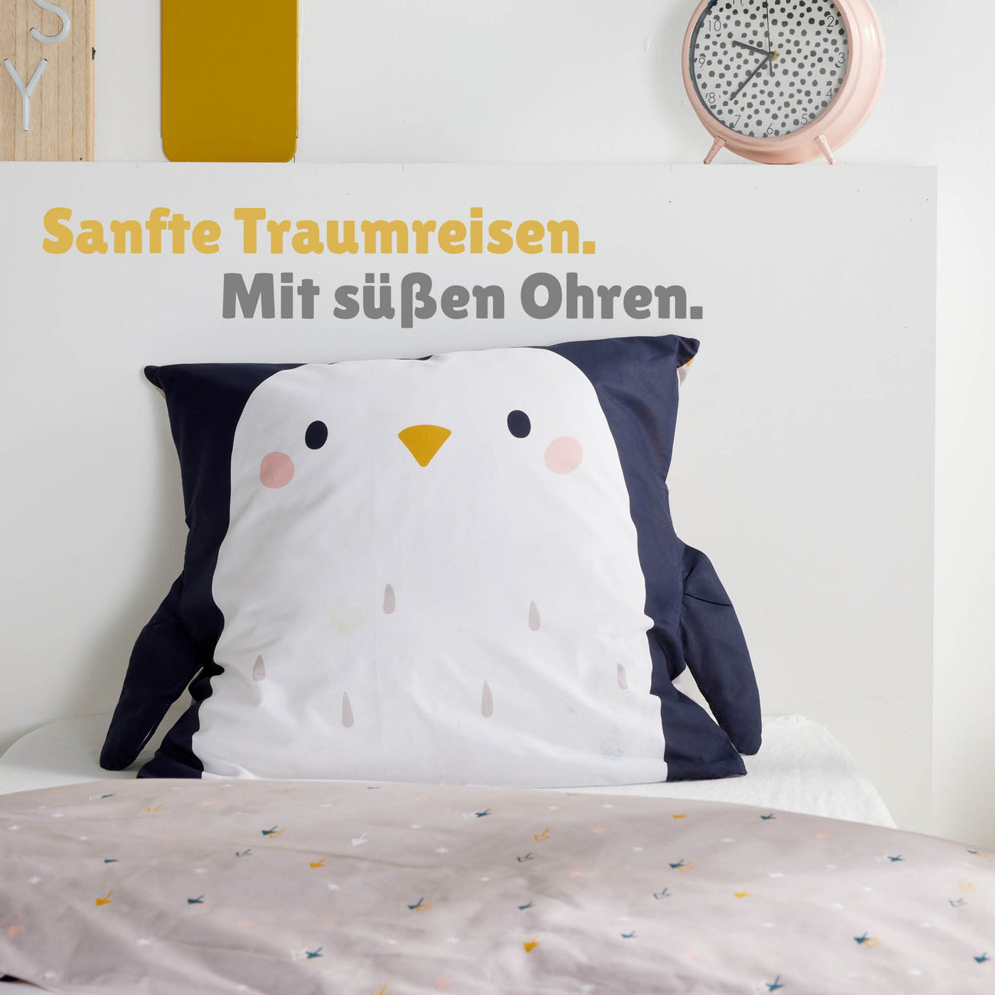 Großaufnahme Kopfkissen in Pinguin Optik mit schwarzen Flügeln links und rechts