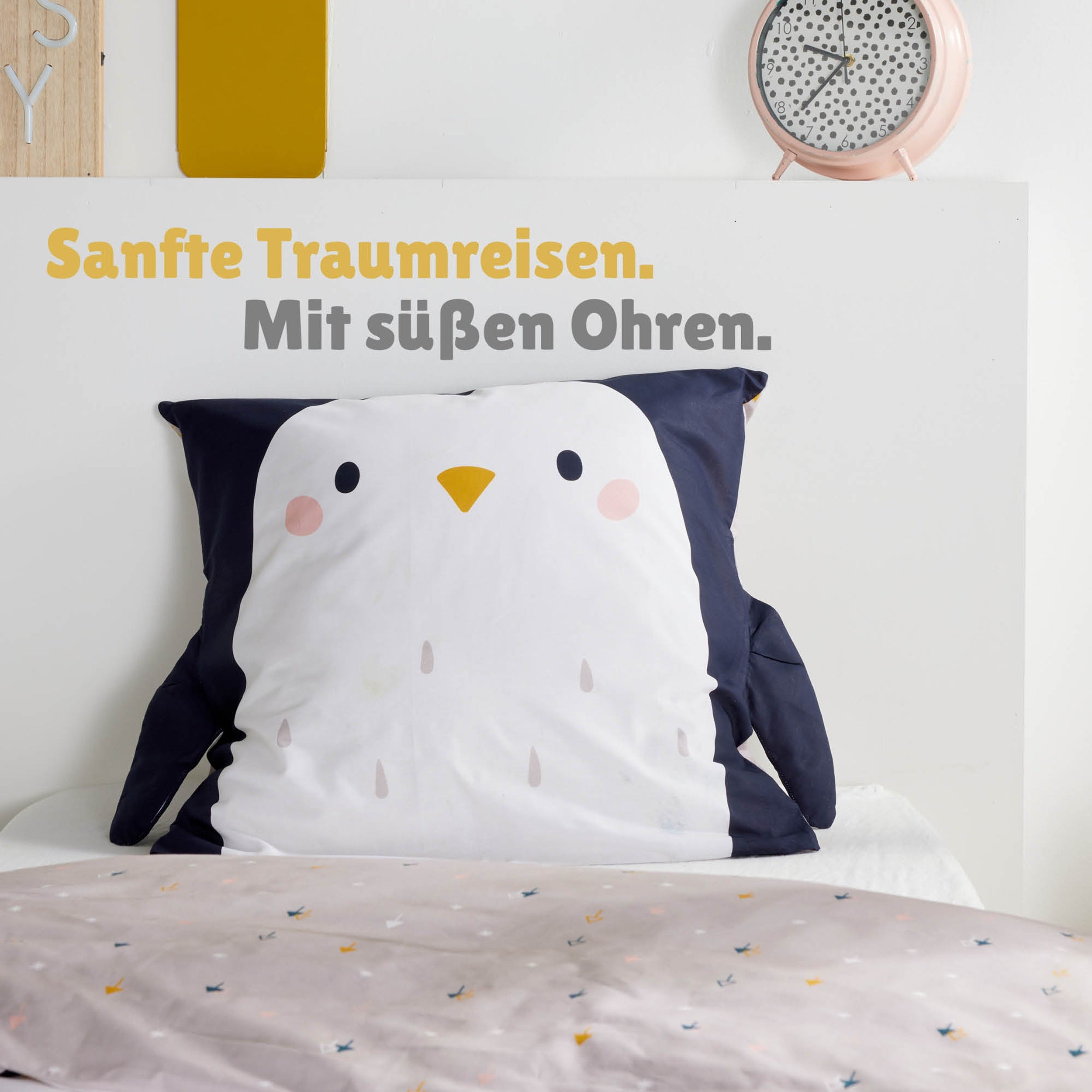Großaufnahme Kopfkissen in Pinguin Optik mit schwarzen Flügeln links und rechts