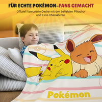 Junge liegt zufrieden auf der Couch in Pokemoen Decke gehüllt
