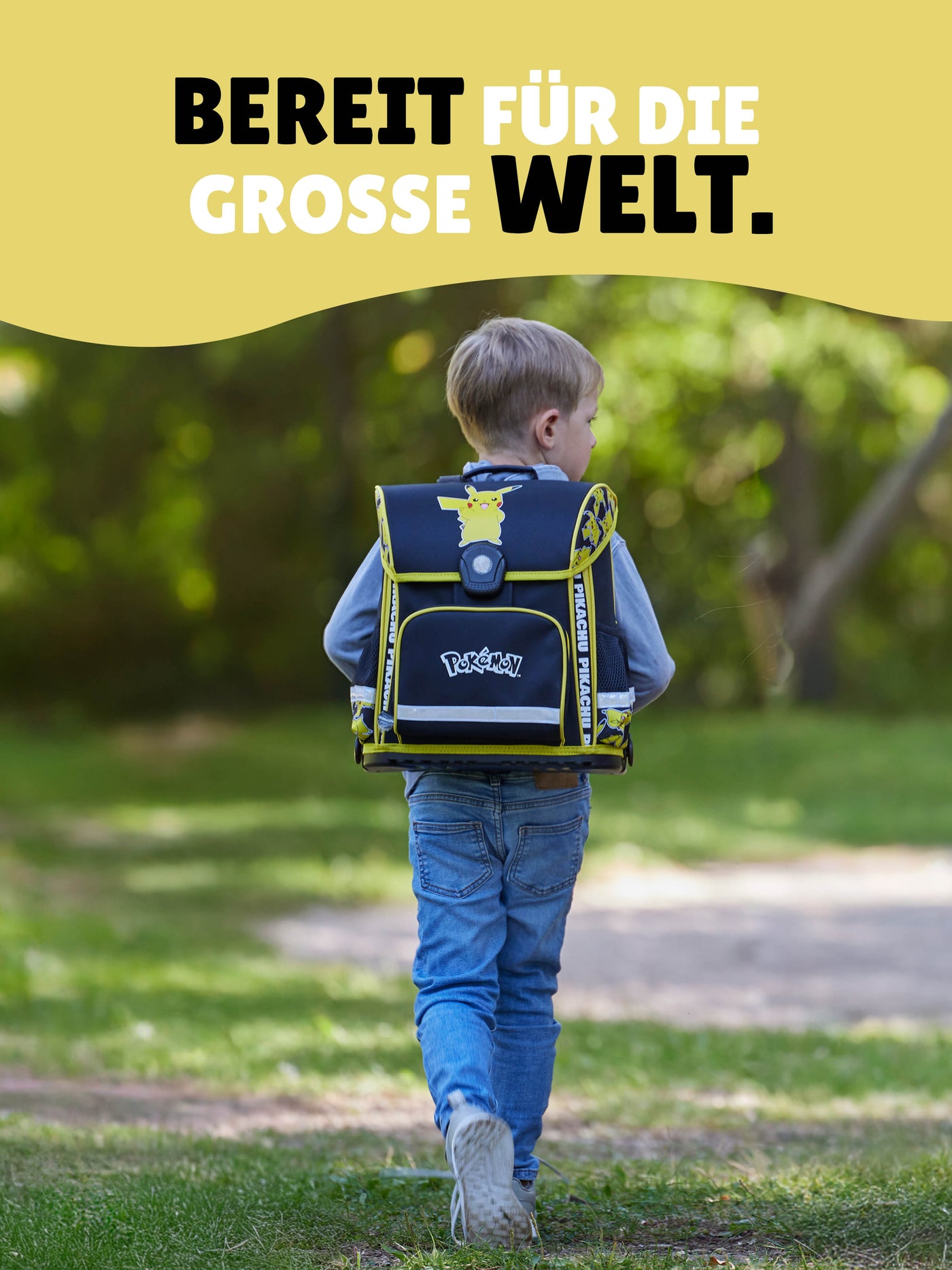Junge läuft durch Park mit gelbem Pokemon Schulranzen auf dem Rücken