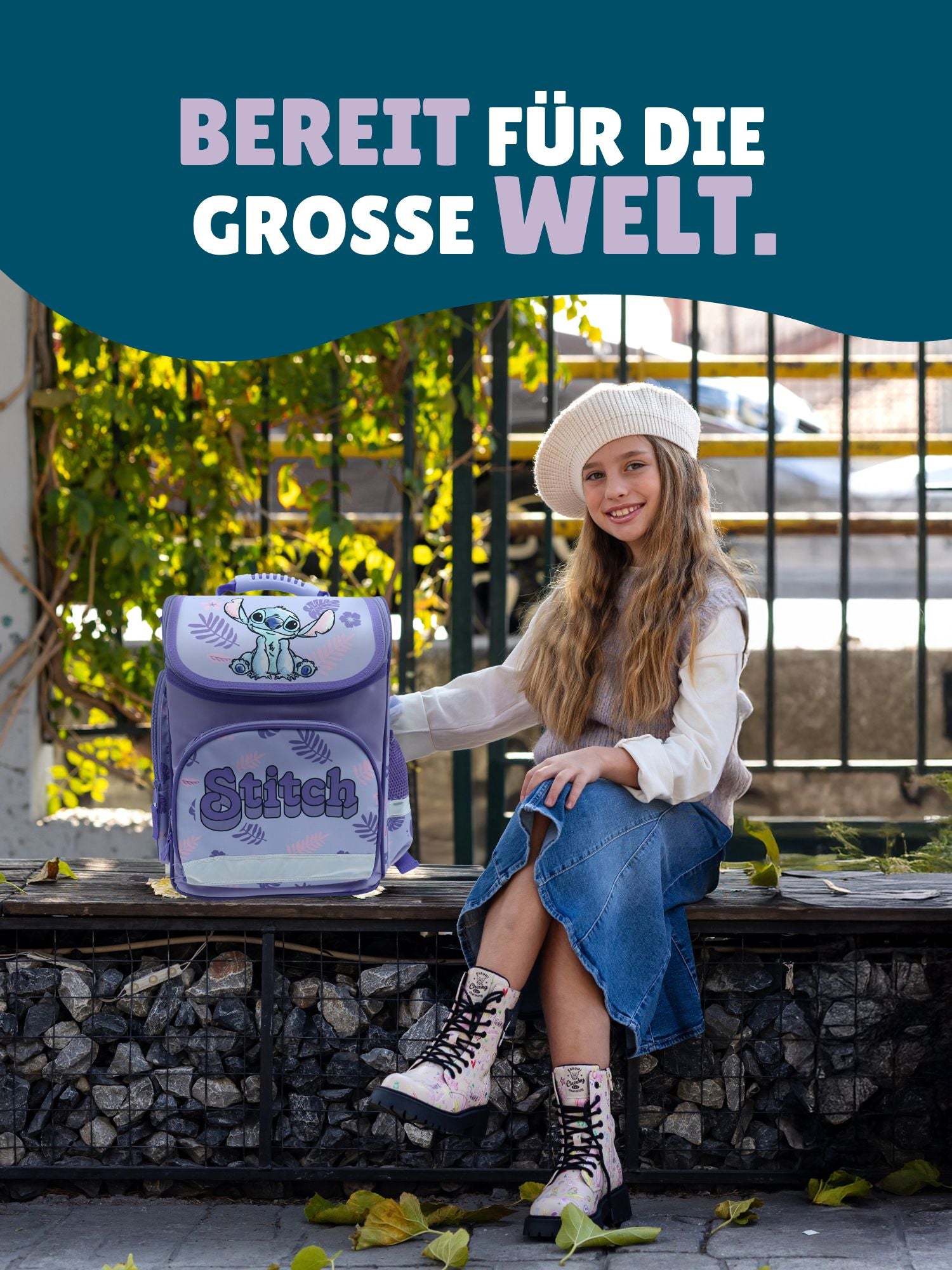 Blondes Mädchen auf Steinbank im Park mit Schulranzen - Spruch "Bereit für die grosse Welt"