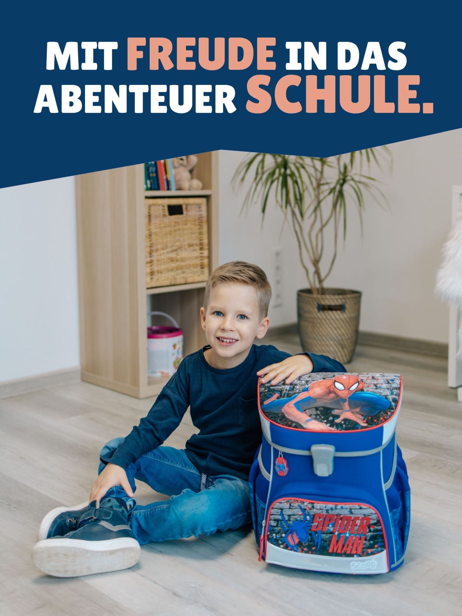 Jungen sitzt neben Schulranzen mit Spruch-Banner "Mit Freude in das Abenteuer Schule"