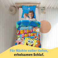 Junge liegt in schön eingerichtetem Zimmer unter der Spongebob Bettwäsche und schläft selig