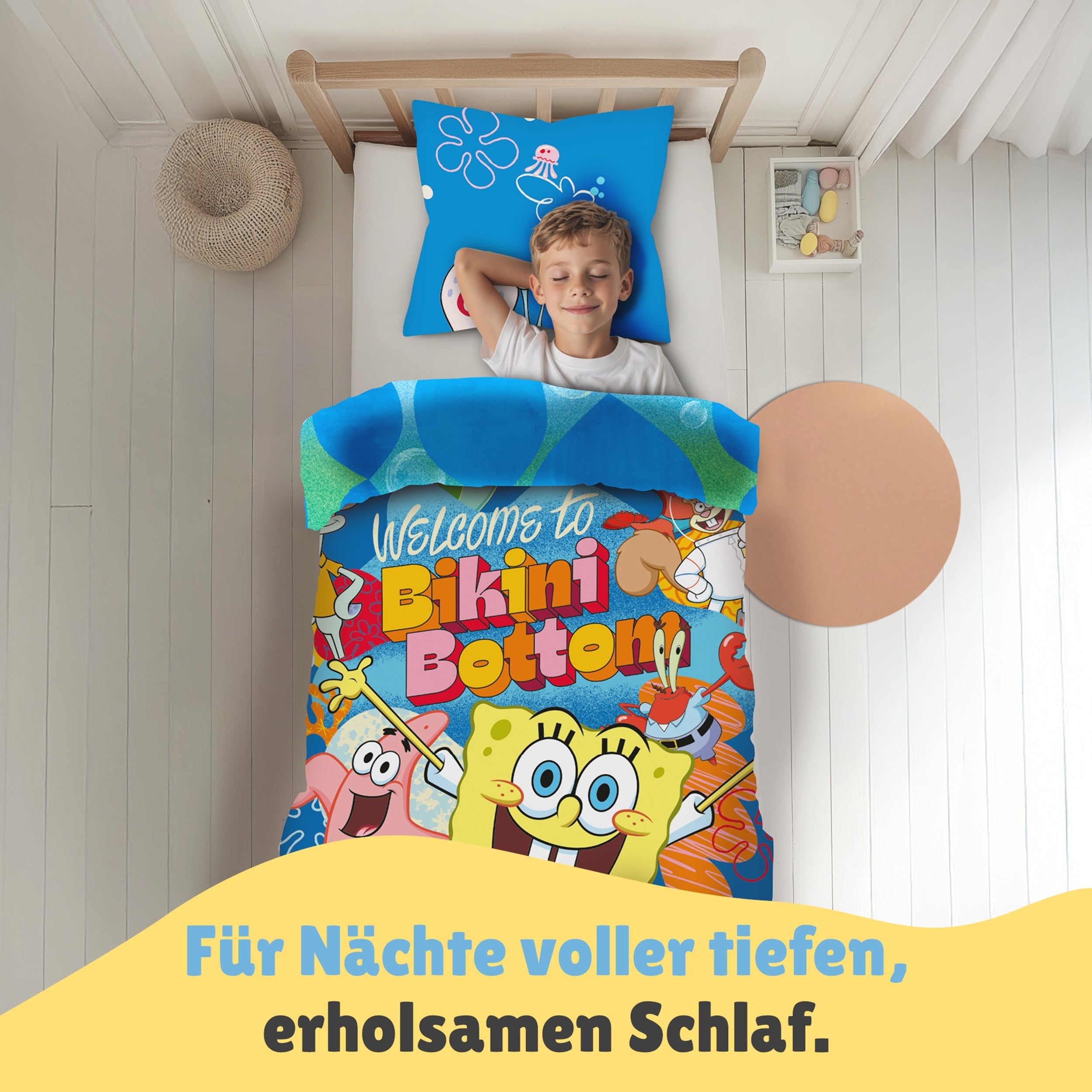 Junge liegt in schön eingerichtetem Zimmer unter der Spongebob Bettwäsche und schläft selig