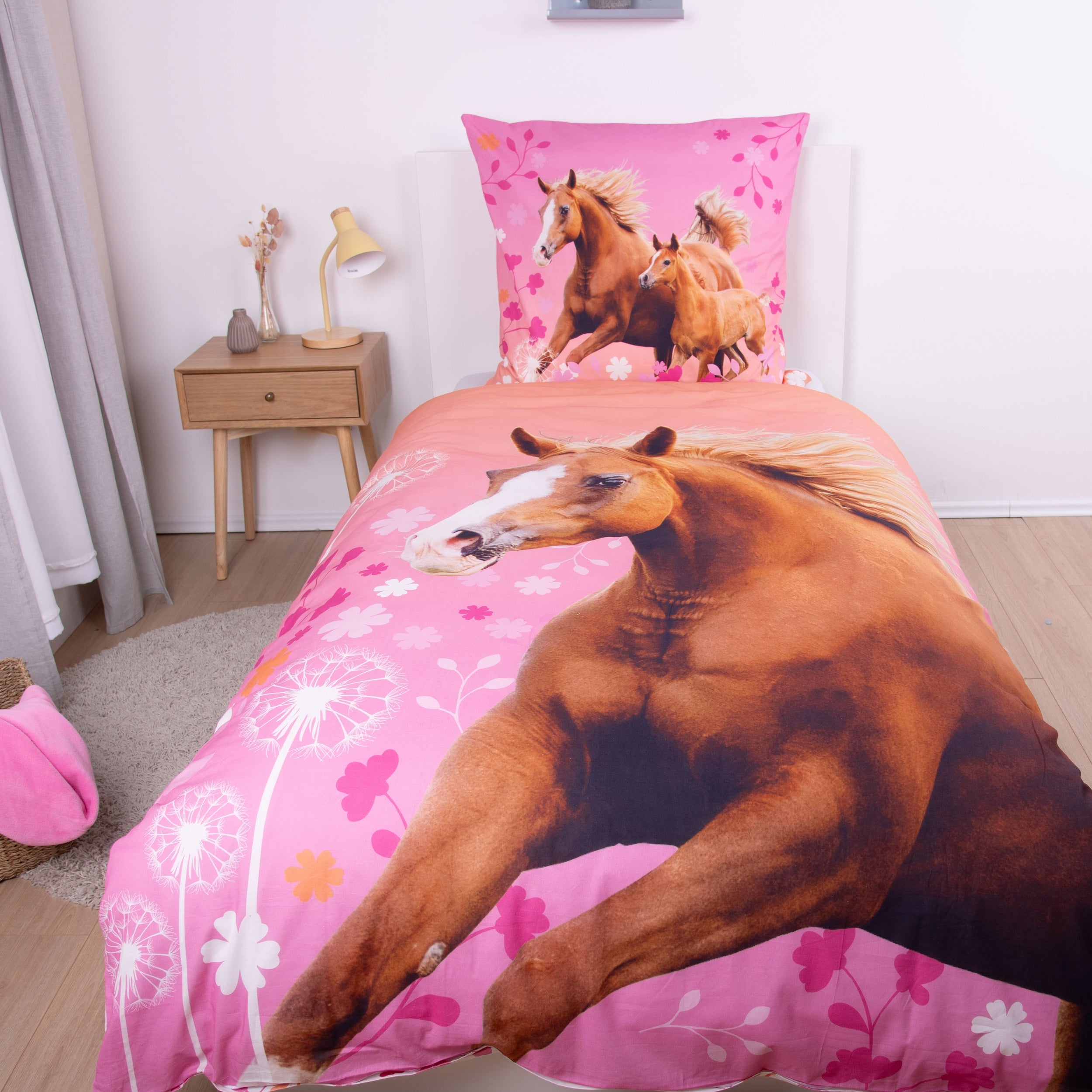 Rosa Pferdebettwäsche mit braunem Pferd als Motiv auf Bett gespannt in schön dekoriertem Zimmer